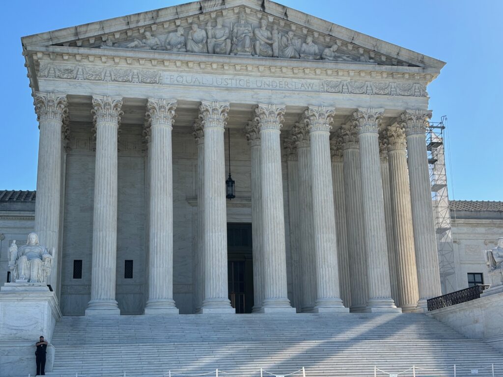 The U.S. Supreme Court building with its iconic columns and steps, under a clear b — Supreme Court mail in voting decision