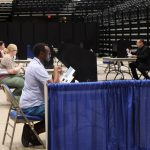 Voters seated at individual booths in a spacious arena, casting their ballots durin — Noncitizen Voter Purge Supreme Court
