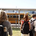 Students walking towards a yellow school bus, highlighting school safety and community. — school panic alarms