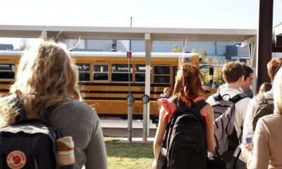 Students walking towards a yellow school bus, highlighting school safety and community. — school panic alarms