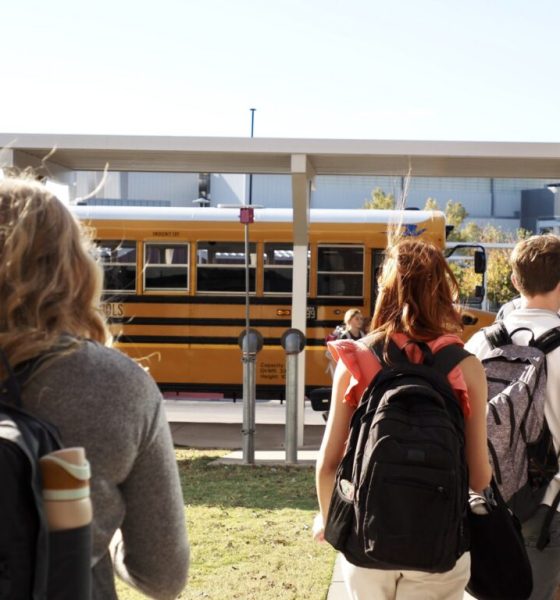 Students walking towards a yellow school bus, highlighting school safety and community. — school panic alarms