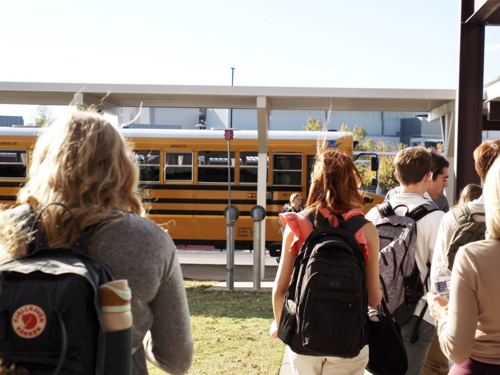 Students walking towards a yellow school bus, highlighting school safety and community. — school panic alarms