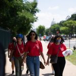 AAPI women reproductive healthcare advocates walk together along a tree-lined Washington, D.C., sidewalk.