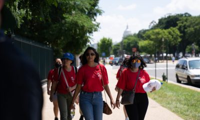 AAPI women reproductive healthcare advocates walk together along a tree-lined Washington, D.C., sidewalk.