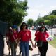 AAPI women reproductive healthcare advocates walk together along a tree-lined Washington, D.C., sidewalk.