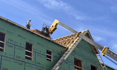 Construction worker on a building site with wooden framing and green insulation pa — Housing Ballot Measures November 2024