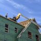 Construction worker on a building site with wooden framing and green insulation pa — Housing Ballot Measures November 2024