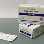 Boxes of mifepristone tablets, a medication used for abortion, displayed on a gray su — Florida abortion pill restrictions