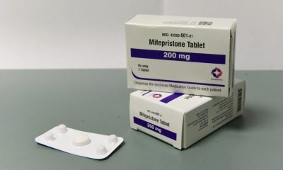 Boxes of mifepristone tablets, a medication used for abortion, displayed on a gray su — Florida abortion pill restrictions