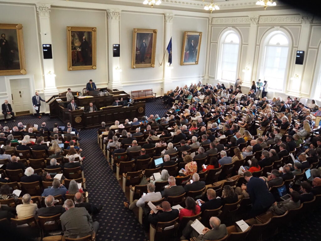 A crowded legislative chamber with numerous attendees and officials dur — state legislative elections competitive chambers