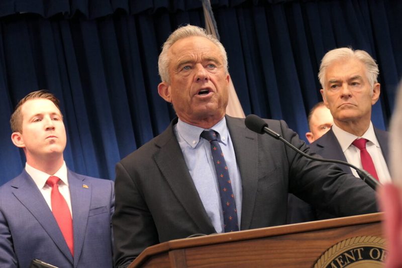 Robert F. Kennedy Jr. speaking at a podium with supporters in the background during a pr — FDA abortion pill safety review