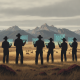Silhouetted ranchers with tablets observe cattle in a Colorado landscape, highlighting HR 10735 cattle crop insurance.