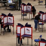 Voters mark ballots in separate privacy booths at an indoor polling place amid Federal Interference Midterm Elections conc…