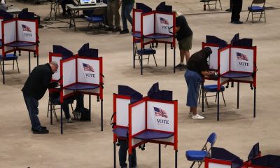 Voters mark ballots in separate privacy booths at an indoor polling place amid Federal Interference Midterm Elections conc…