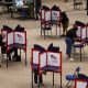 Voters mark ballots in separate privacy booths at an indoor polling place amid Federal Interference Midterm Elections conc…