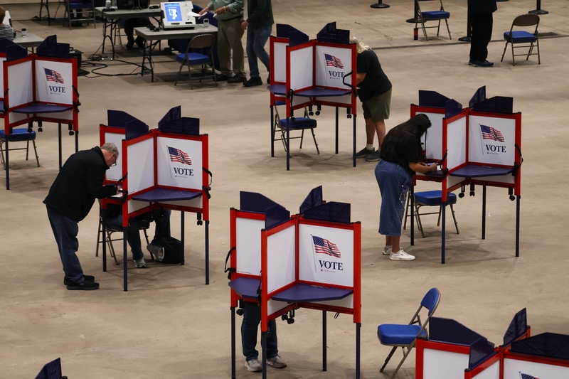 Voters mark ballots in separate privacy booths at an indoor polling place amid Federal Interference Midterm Elections conc…