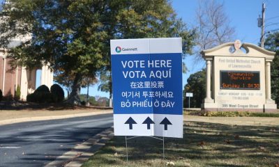 DHS naturalized citizen voter lawsuit context: multilingual “Vote Here” sign outside a church polling place.