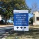 DHS naturalized citizen voter lawsuit context: multilingual “Vote Here” sign outside a church polling place.