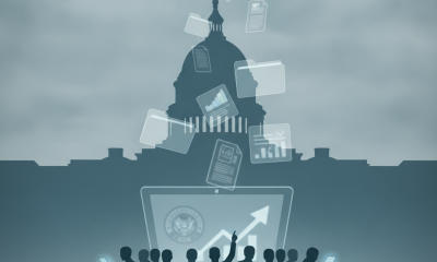 Silhouetted figures holding devices in front of the Capitol building, — National Cemetery Administration Annual Report Act