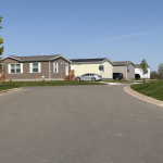 Quiet street lined with manufactured homes and parked cars — Manufactured Home Chassis Federal Law