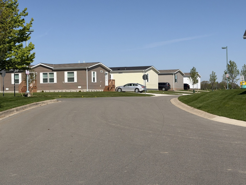 Quiet street lined with manufactured homes and parked cars — Manufactured Home Chassis Federal Law