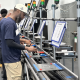 Workers operate equipment on an automotive production line amid discussion of States Losing Jobs and job growth.