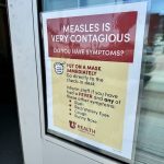 A sign warning about the contagious nature of measles, instructing people to wear masks an — Pennsylvania Measles Outbreak