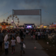 Pensacola Interstate Fair 2026 at dusk, with families walking past a lit Ferris wheel and concert stage.